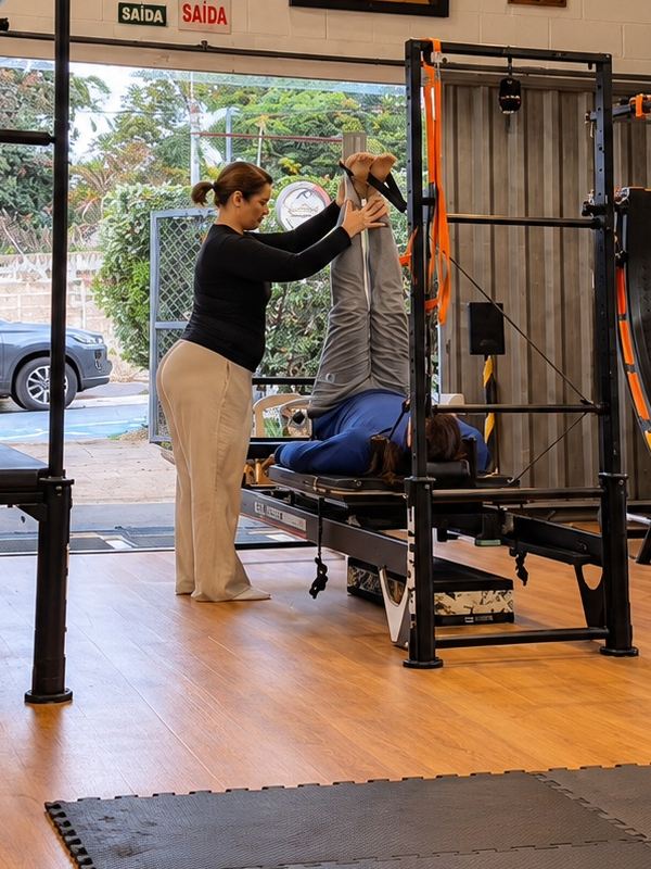 Instrutora orientando um exercício no aparelho