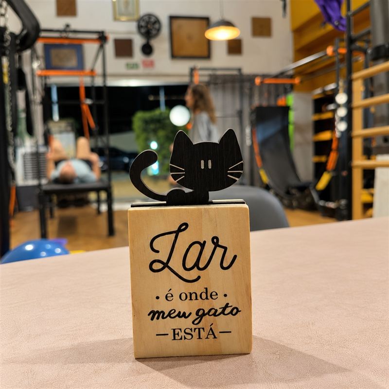 Plaquinha de madeira com um gato preto e a frase: Lar é onde meu gato está